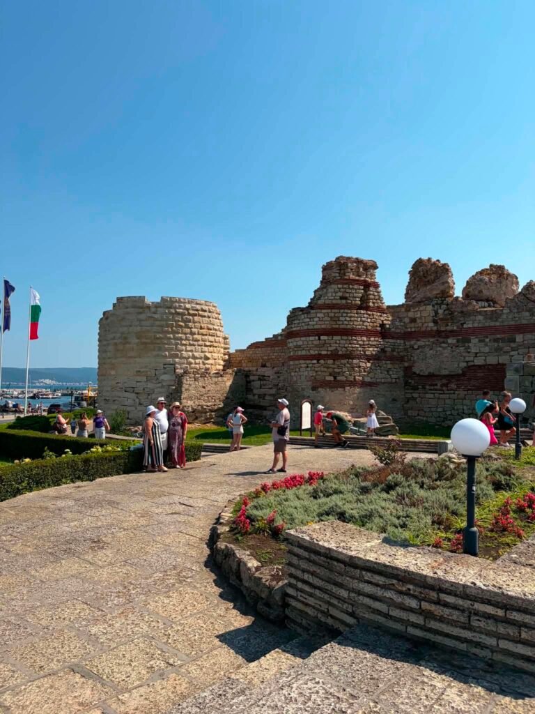 The historic stone fortress walls of Nesebar under a clear blue sky, showing layers of ancient Roman and Byzantine architecture.