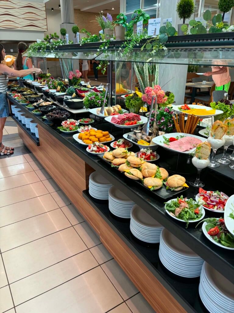 well-organized all-inclusive buffet counter at the DIT Evrika Beach Club Hotel, featuring a wide variety of colorful fresh salads, hot dishes, meats, and side options beautifully displayed for guests